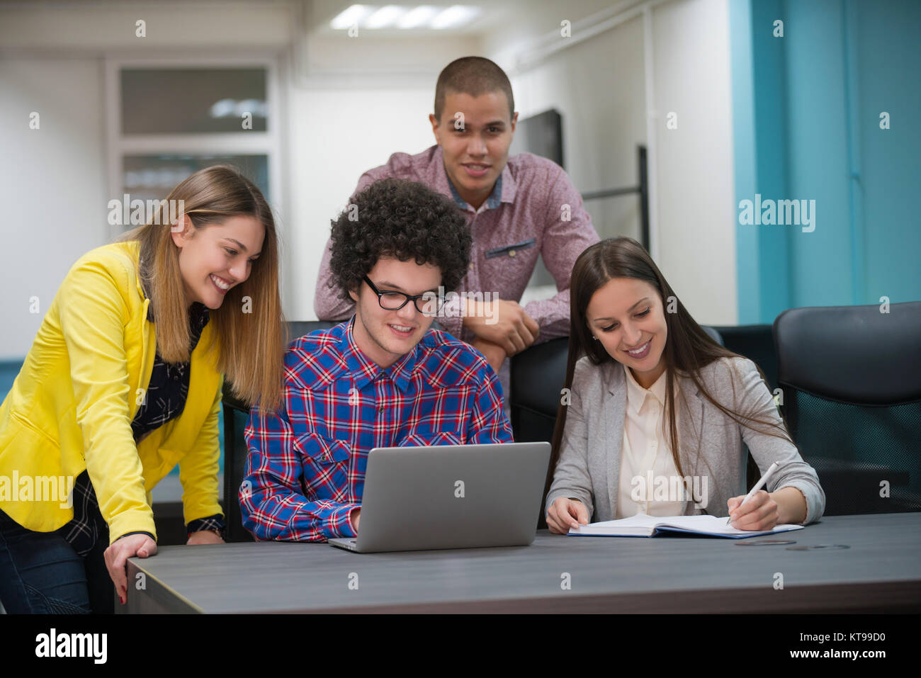 Portrait de groupe de démarrage de créateurs d'une réunion avec un ordinateur portable dans un bureau moderne. Les gens d'affaires ayant conversation détendue plus de nouveaux p Banque D'Images