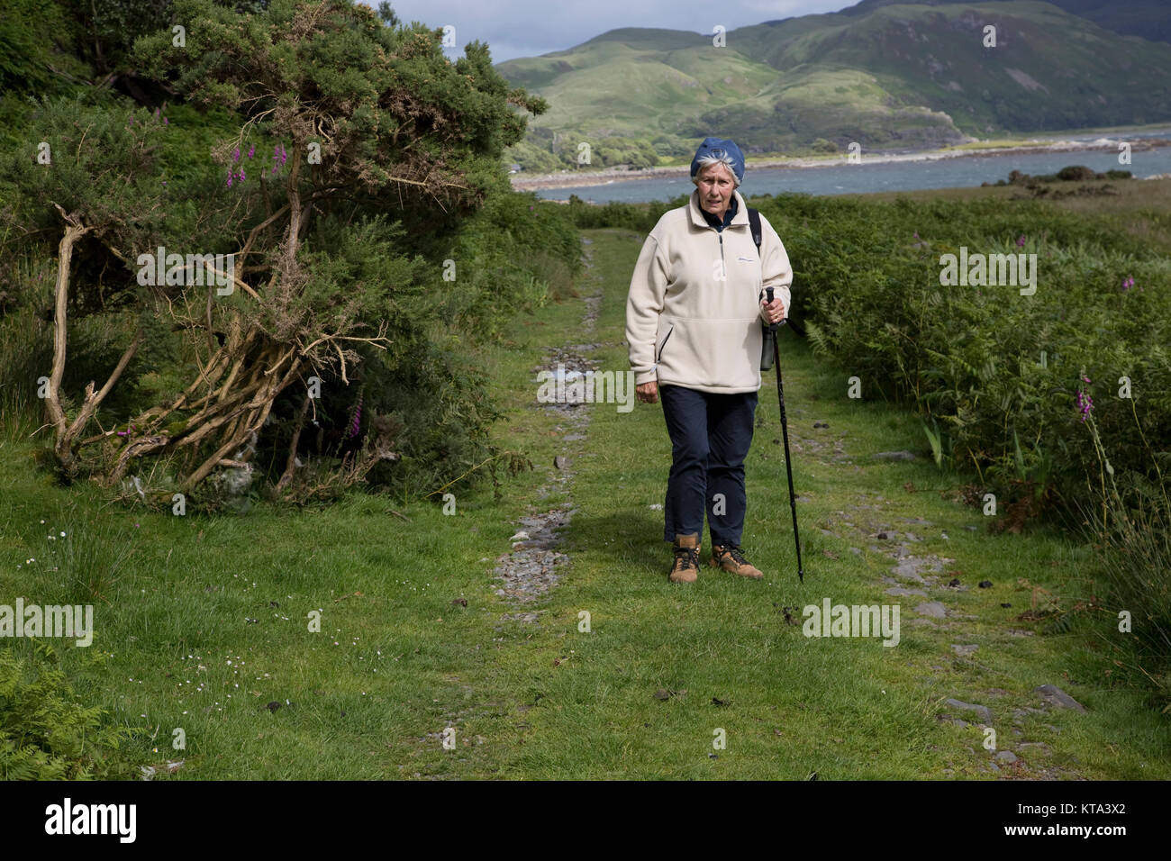 Senior woman with stick à marcher le long du sentier côtier Mull Ecosse Banque D'Images