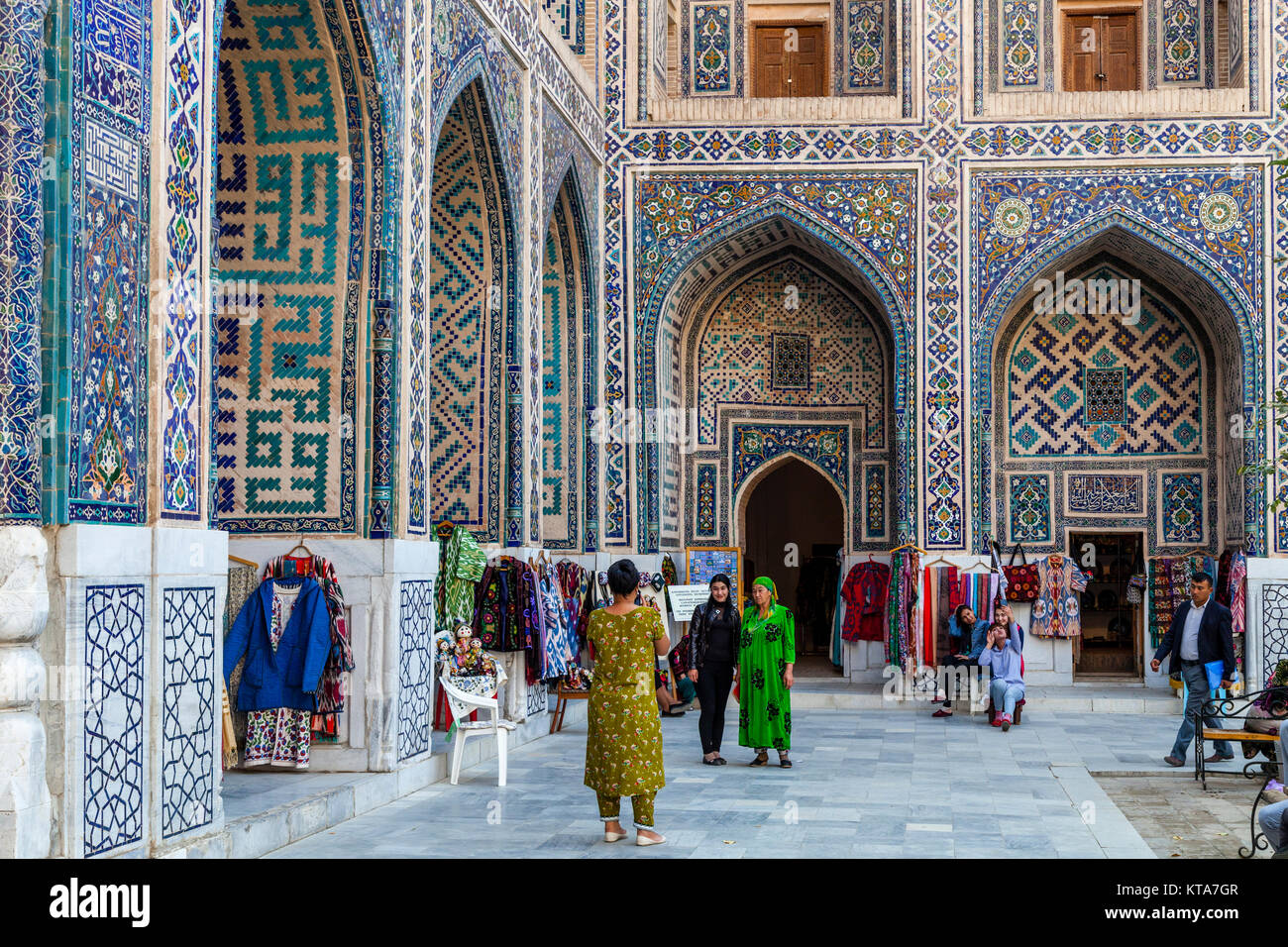 Femmes ouzbeks qui pose pour des photos à l'intérieur de la Madrasa Ulugh Beg, le Reghistan, Samarkand, Ouzbékistan Banque D'Images