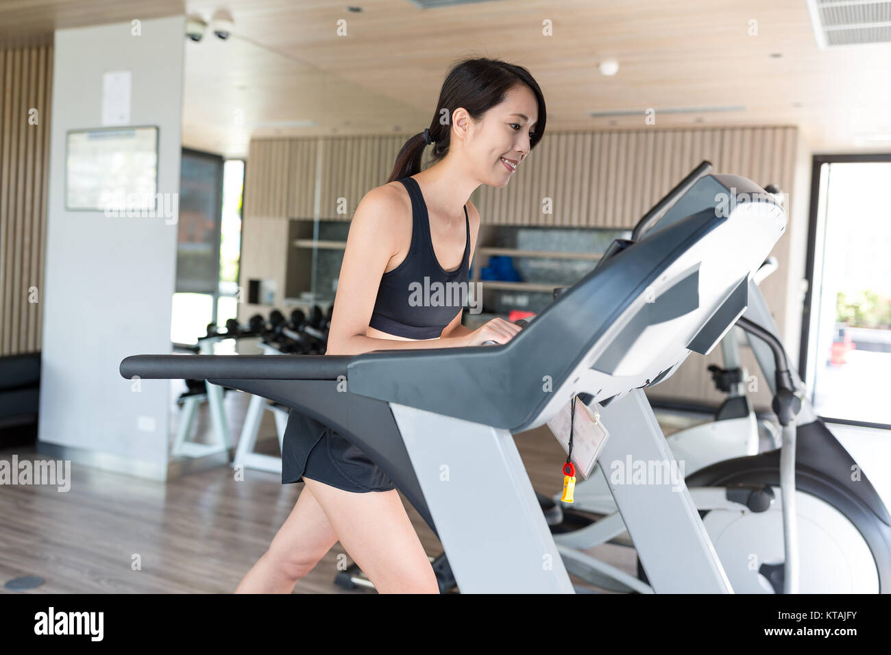 Woman running on treadmill in gym Banque D'Images