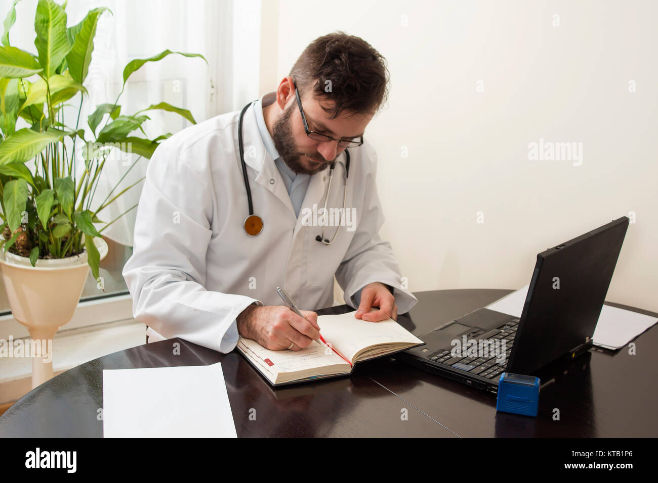 un médecin en manteau blanc est entré dans votre stylo de calendrier. Banque D'Images