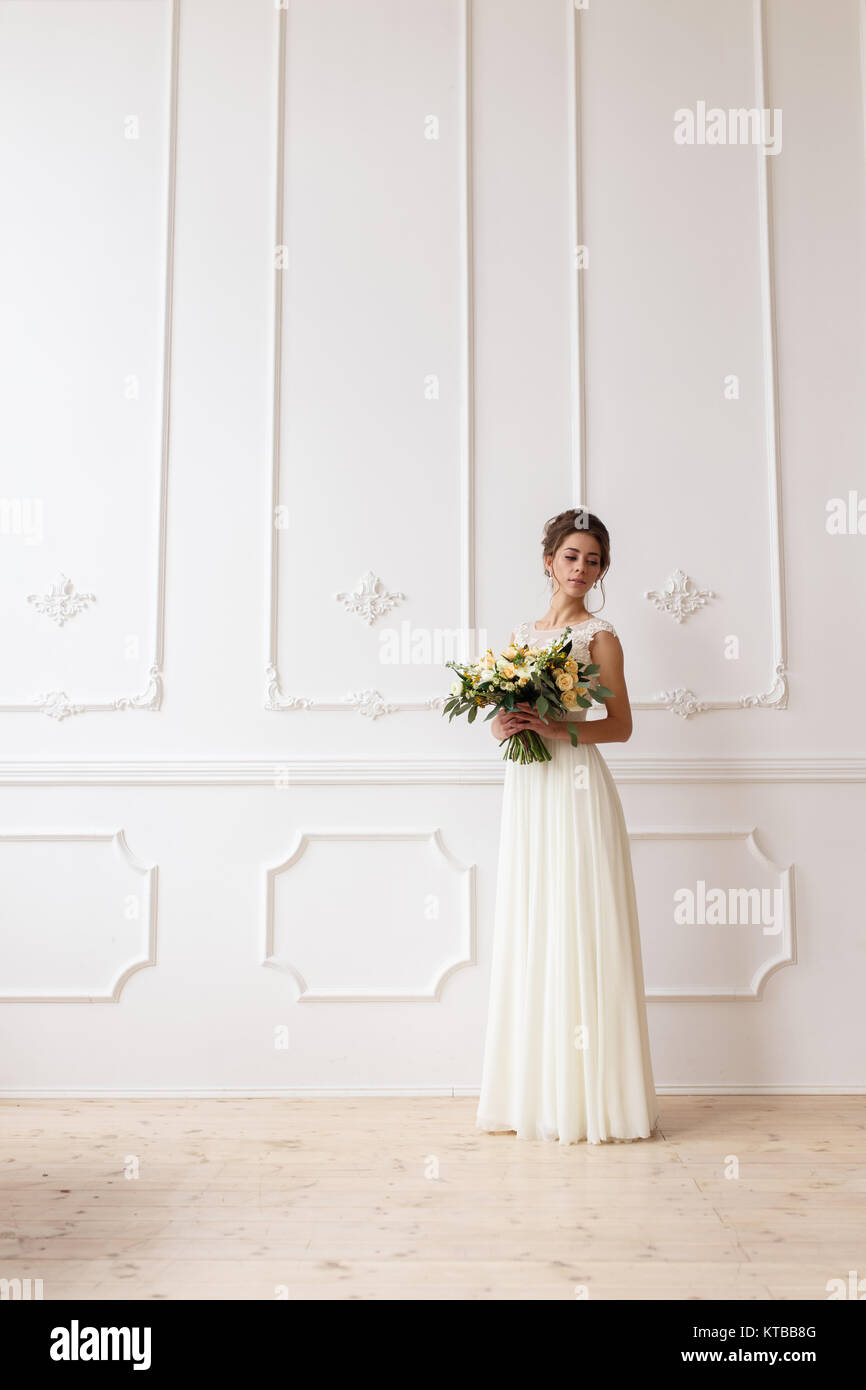 Bride holding bouquet mariage boho sur fond de mur blanc relief Banque D'Images