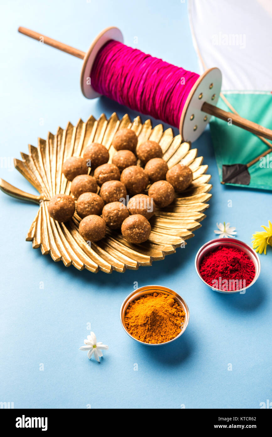 Heureux Makar Sankranti carte de souhaits - Tilgul ou Til ladoo dans un bol ou une assiette avec haldi et kumkum fleurs avec Fikri /Bobine/Chakri /tiroir avec colorf Banque D'Images