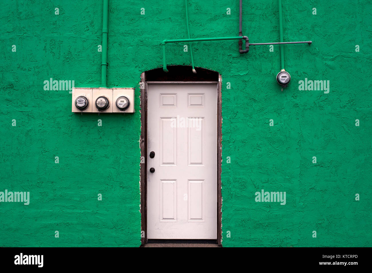 Bâtiment peint, mur vert avec porte blanche avec compteurs de services publics Banque D'Images