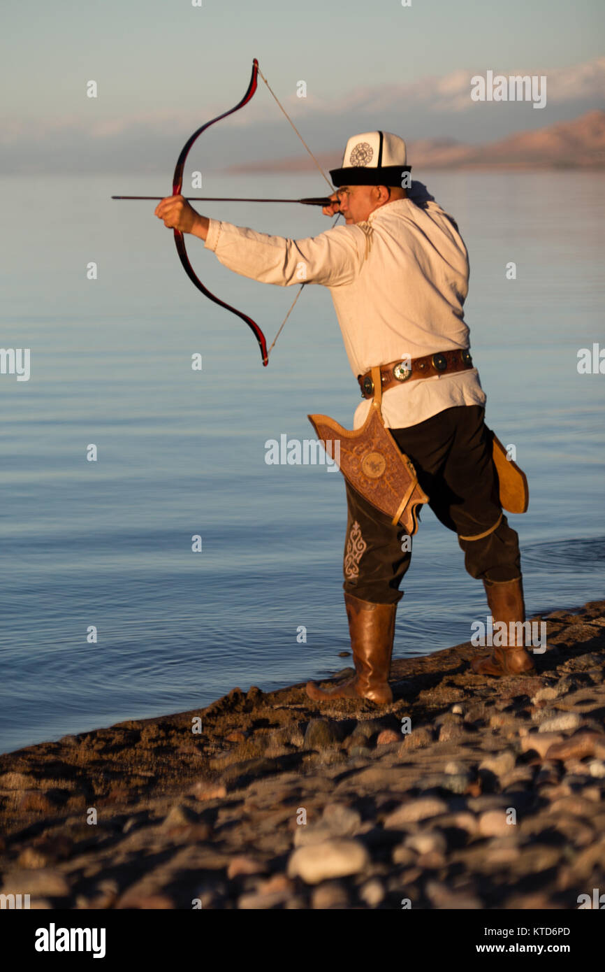 Akynov Almaz, chef du groupe de chasse traditionnel Fédération Salburuun, pose pour des photos sur la rive du lac de Issyk-Kol. Banque D'Images