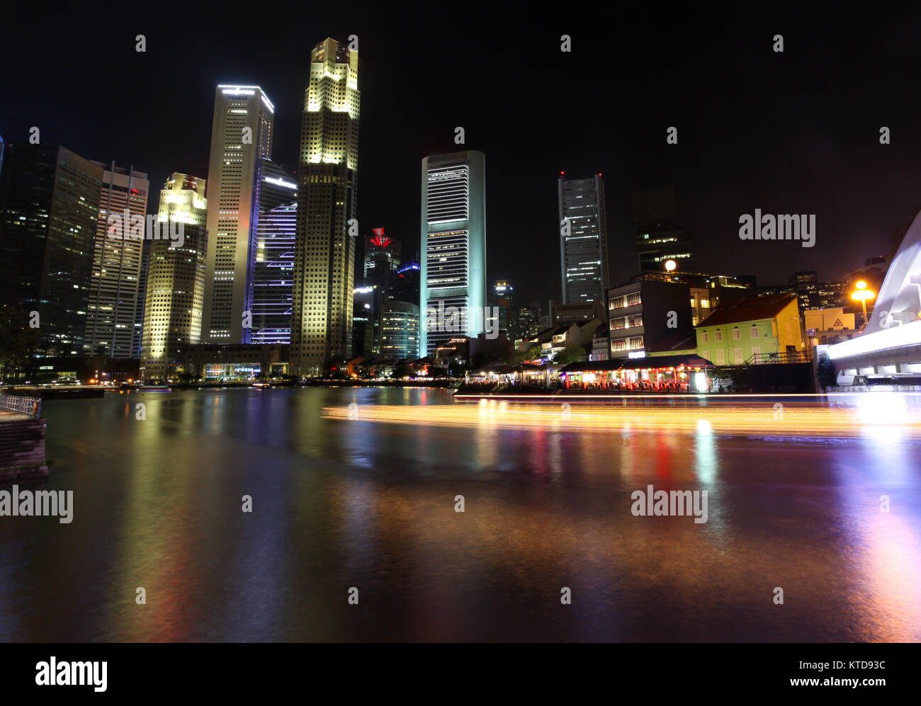 La nuit, à Singapour à South Bridge Road montrant les bâtiments illuminés et des bateaux touristiques sentier à partir de la croisière de la rivière Singapour. Banque D'Images