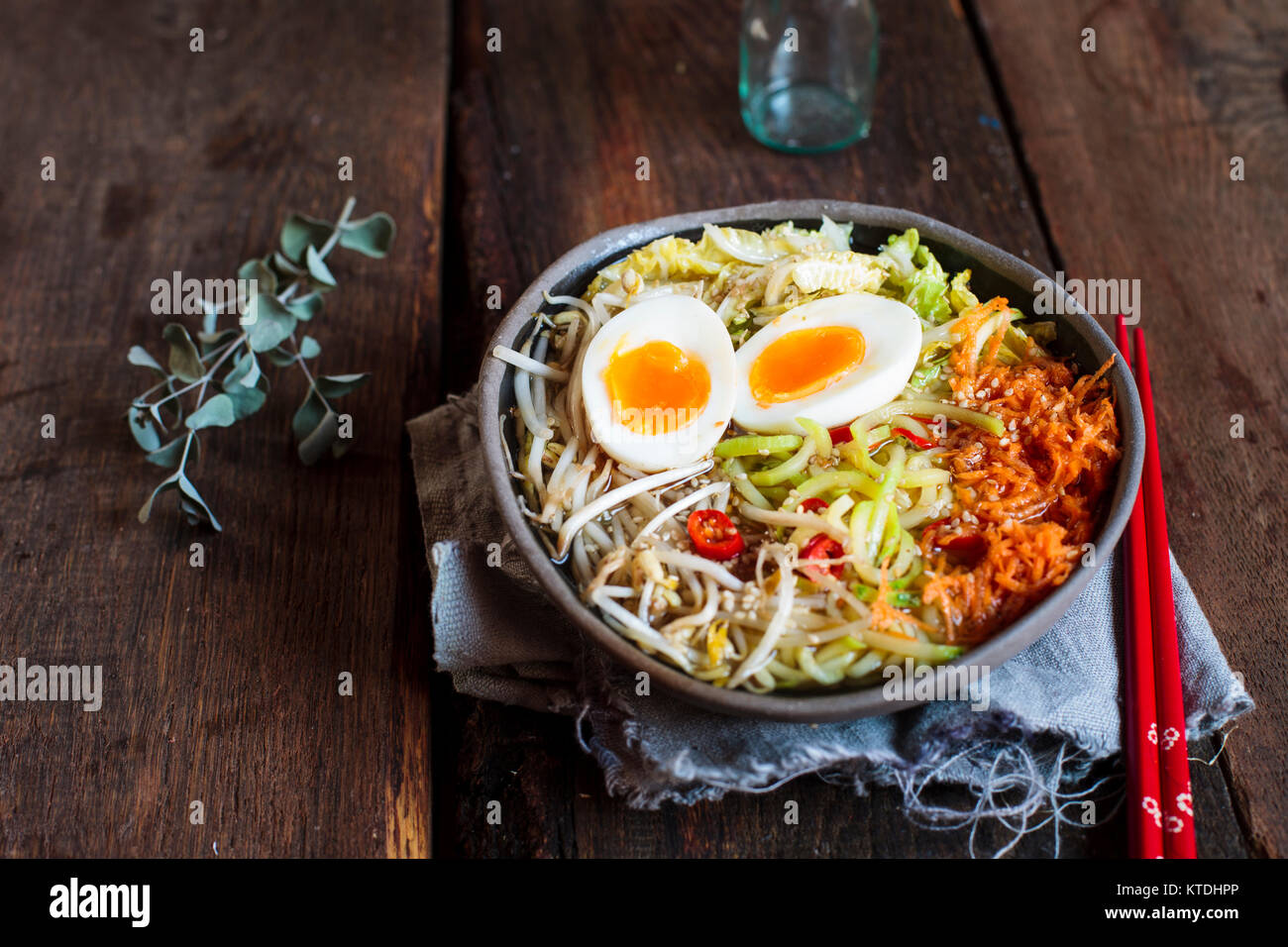 Bol de soupe de nouilles Udon sans gluten avec des carottes, chou chinois, germes de haricots mungo, zoodles et oeuf dur Banque D'Images