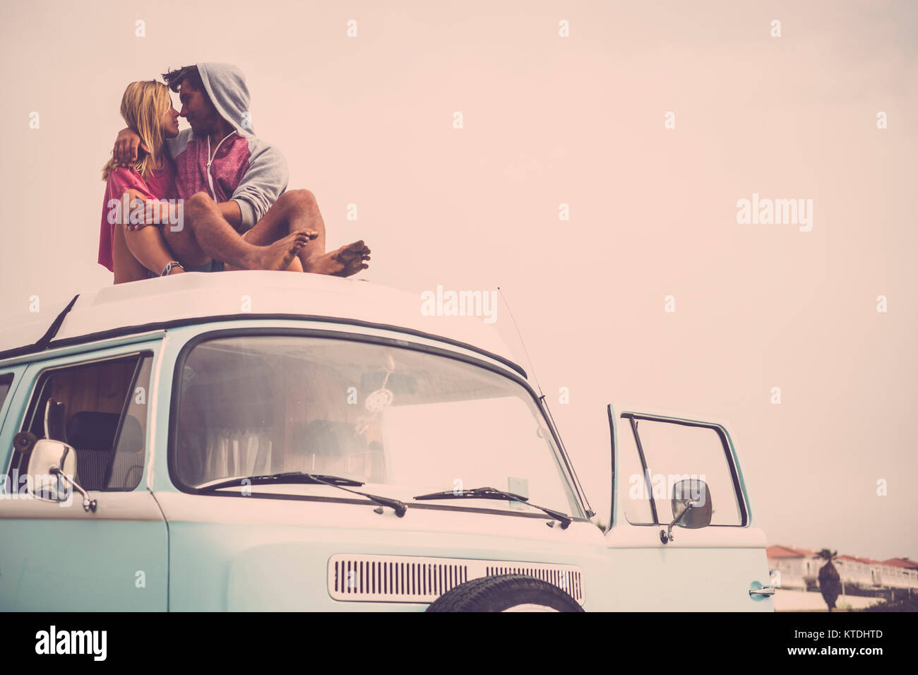 Jeune femme assise sur le toit de la voiture de van Banque de ...