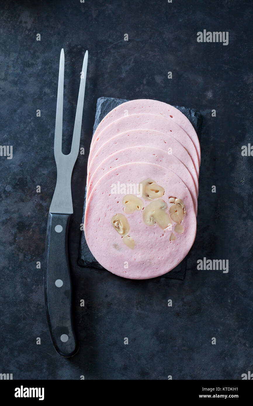 Tranches de saucisse de viande aux champignons avec fourchette à viande Banque D'Images