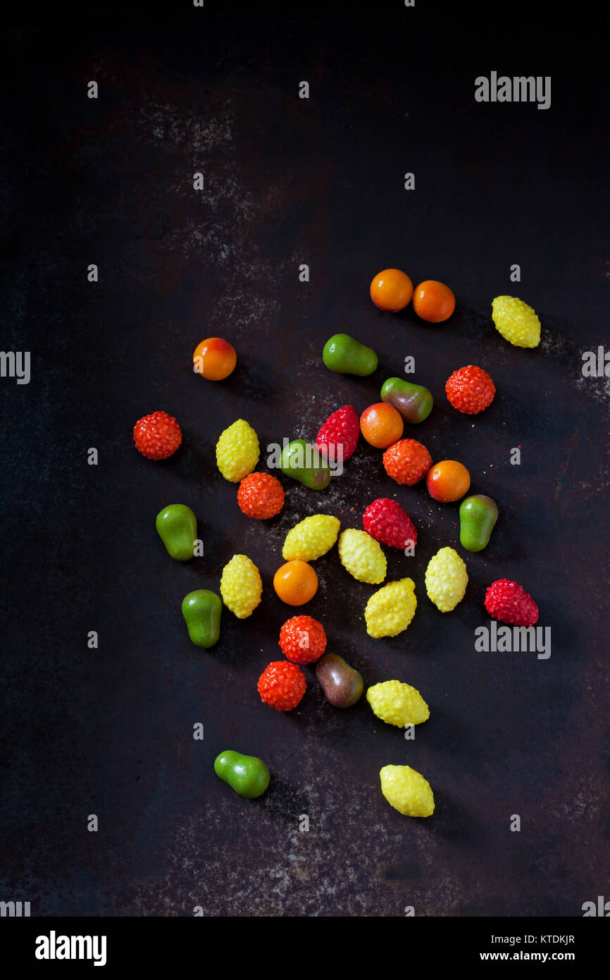 Les chewing-gums en forme de fruits sur la masse sombre Banque D'Images