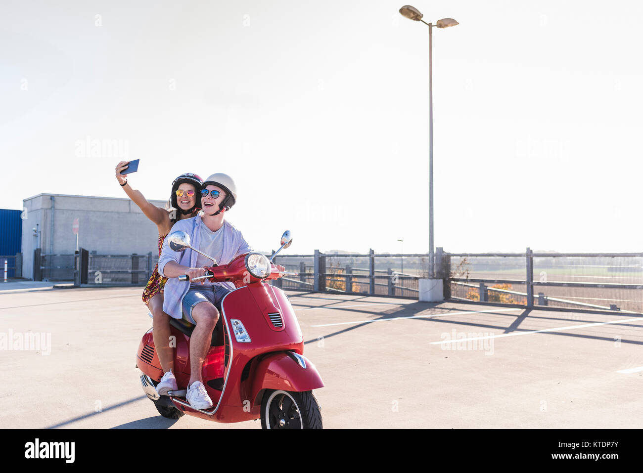 Couple de prendre un scooter sur selfies sur niveau parking Banque D'Images