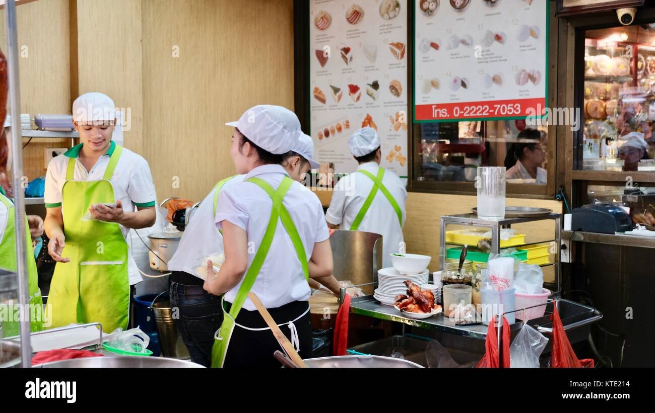 Cuisiniers cuisinant dans la cuisine extérieure sur Yaowarat Road à l'entrée principale du restaurant Hua Seng Hong, Chinatown Bangkok Thaïlande Banque D'Images