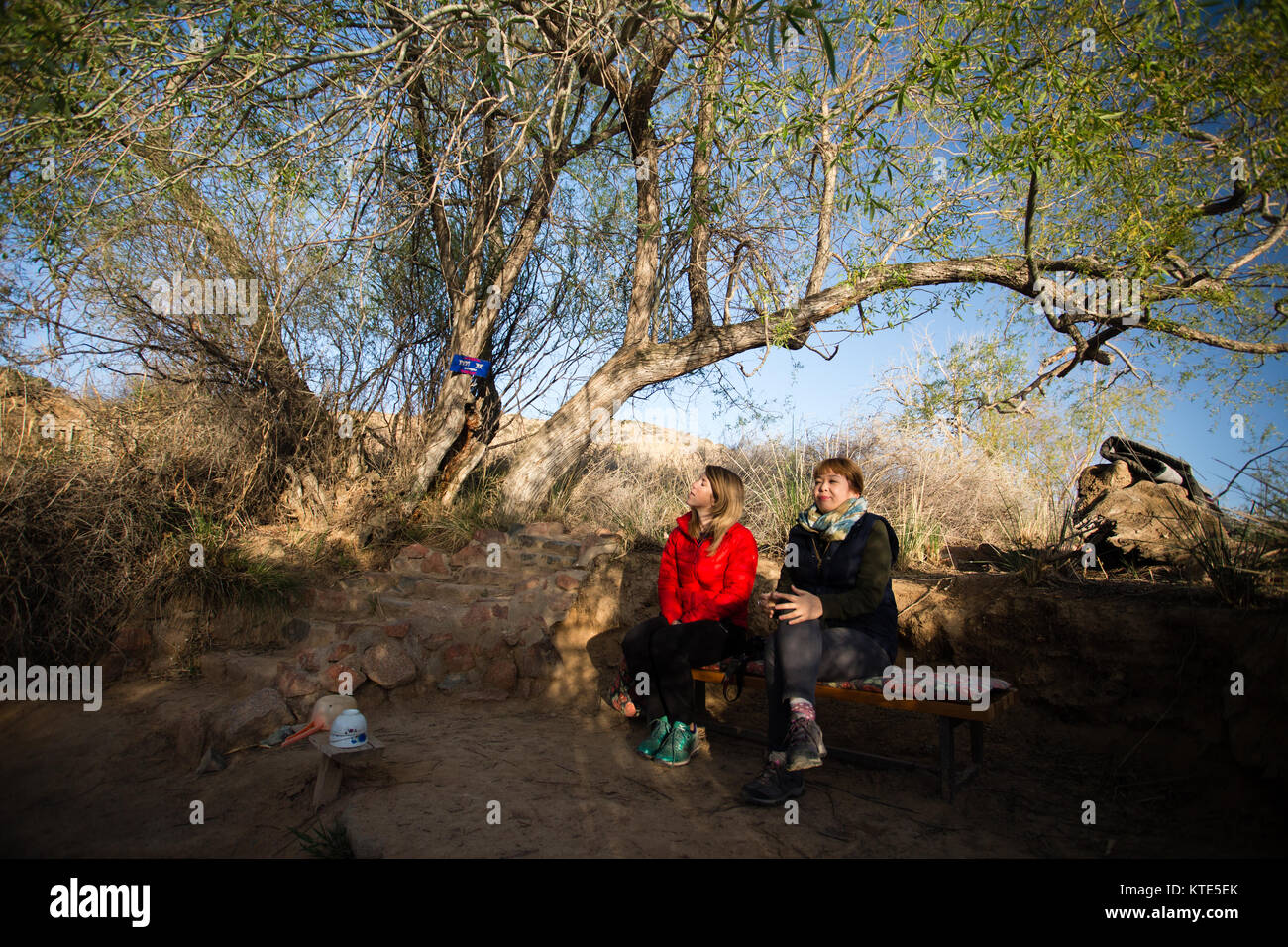 Deux touristes femmes assis à côté d'un printemps Saint au lieu de pèlerinage de Manjyly-ATA dans l'oblast d'Issyk-Kol au Kirghizstan. Banque D'Images