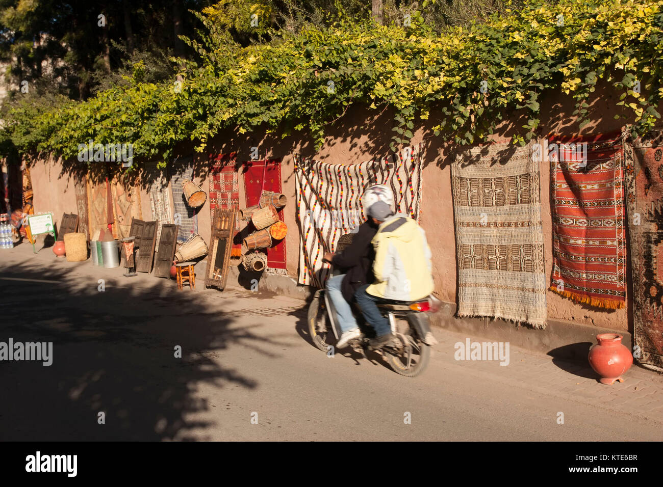 Les hommes sur un scooter cours des marchandises, rue souq impromptus, à Marrakech, Maroc Banque D'Images