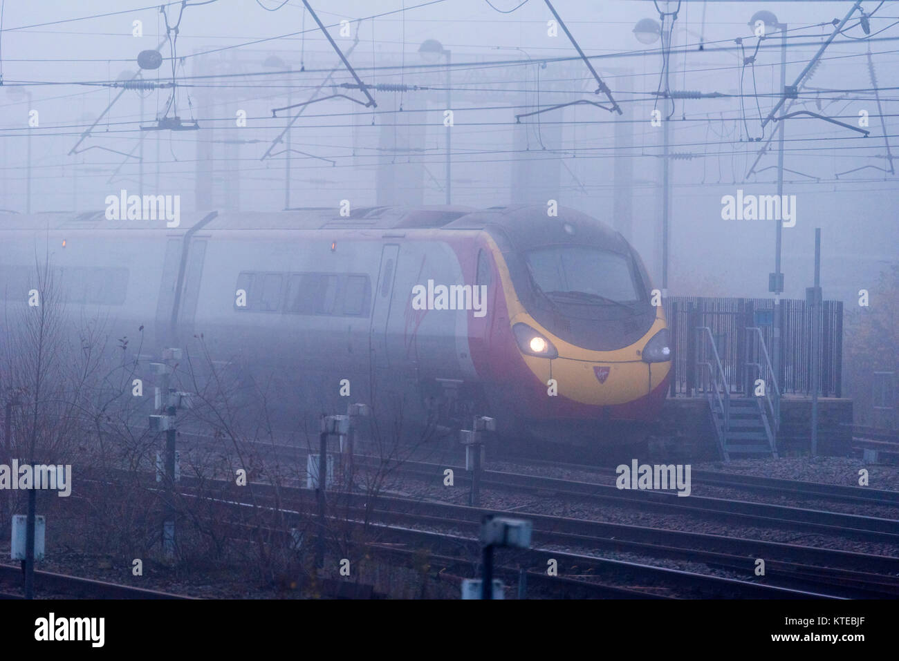 Pendolino Virgin train électrique dans la brume à Warrington Bank Quay station. Banque D'Images