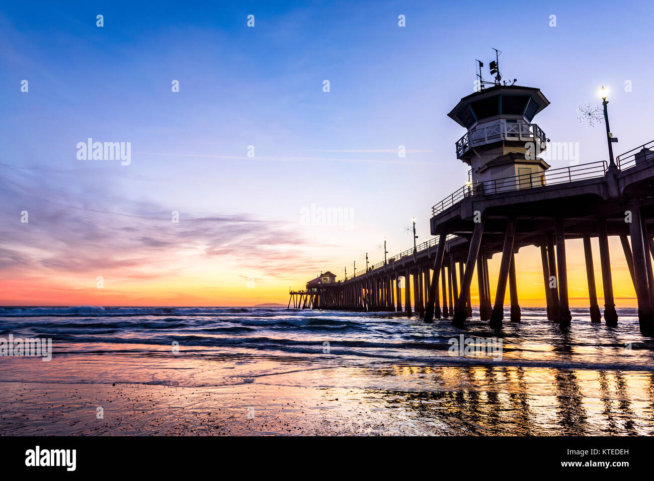 Paysage surréaliste au coucher du soleil au-dessous de l'horizon le long de Huntington Beach, jetant une belle lueur et paysage paisible. Banque D'Images
