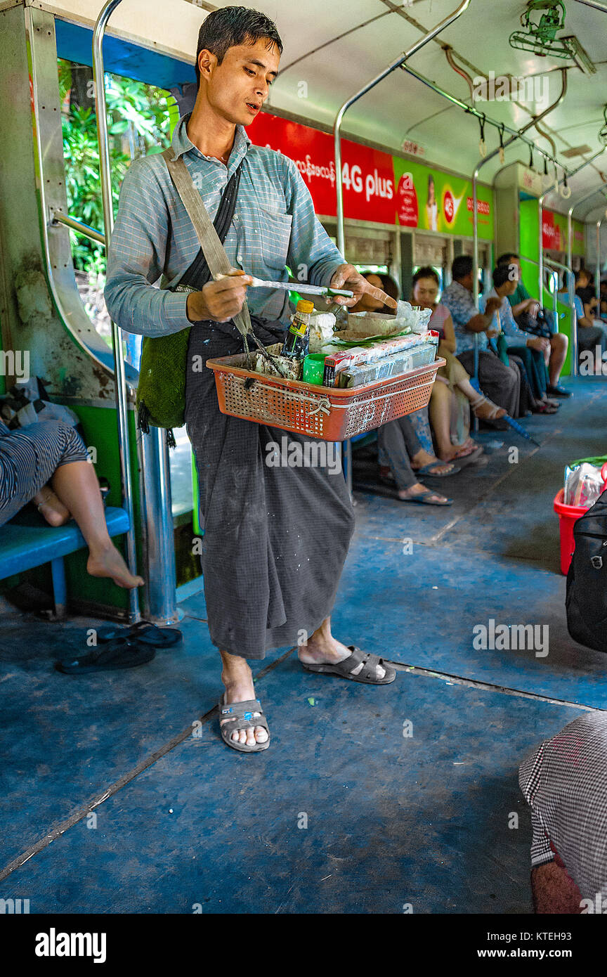 Yangon, Myanmar - Oct 22, 2017 : Un vendeur sur la ligne circulaire est la préparation d'arec avec pâte de chaux éteinte et l'enveloppa dans la feuille de bétel à un client Banque D'Images