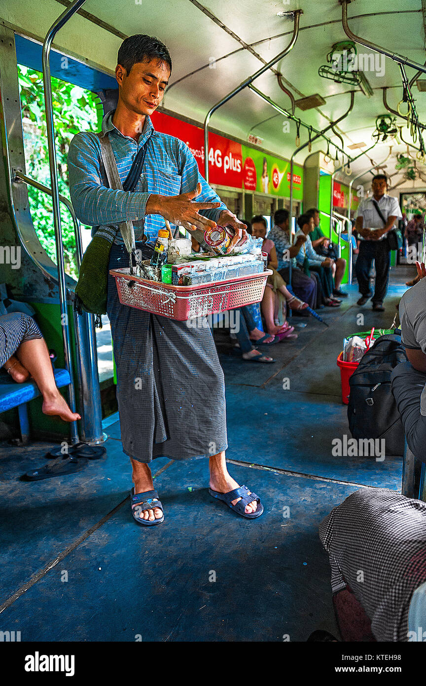 Yangon, Myanmar - Oct 22, 2017 : Un vendeur sur la ligne circulaire est la préparation d'arec avec pâte de chaux éteinte et l'enveloppa dans la feuille de bétel à un client Banque D'Images