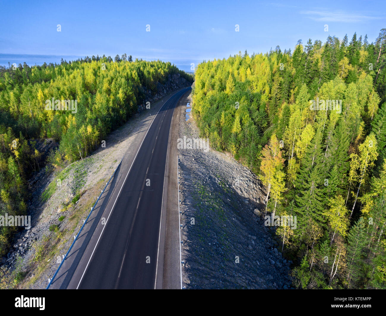 La route asphaltée passant en tunnel rock à l'automne les forêts de Carélie, en Russie. La route de Kola Banque D'Images