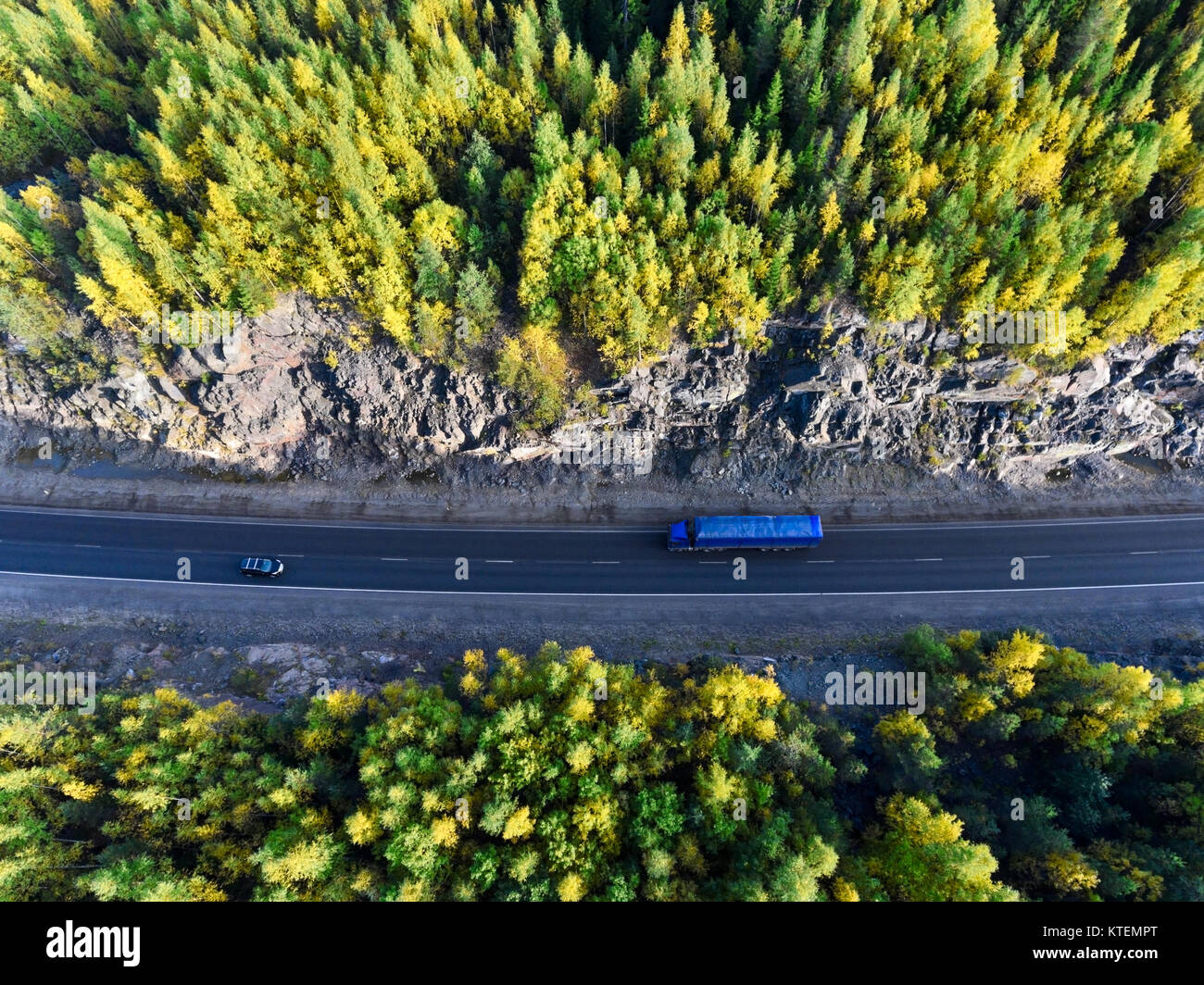 Vue de dessus du blue semi-remorque de camion entre le tunnel de roche verte et jaune à l'automne les forêts de Carélie, Russie Banque D'Images