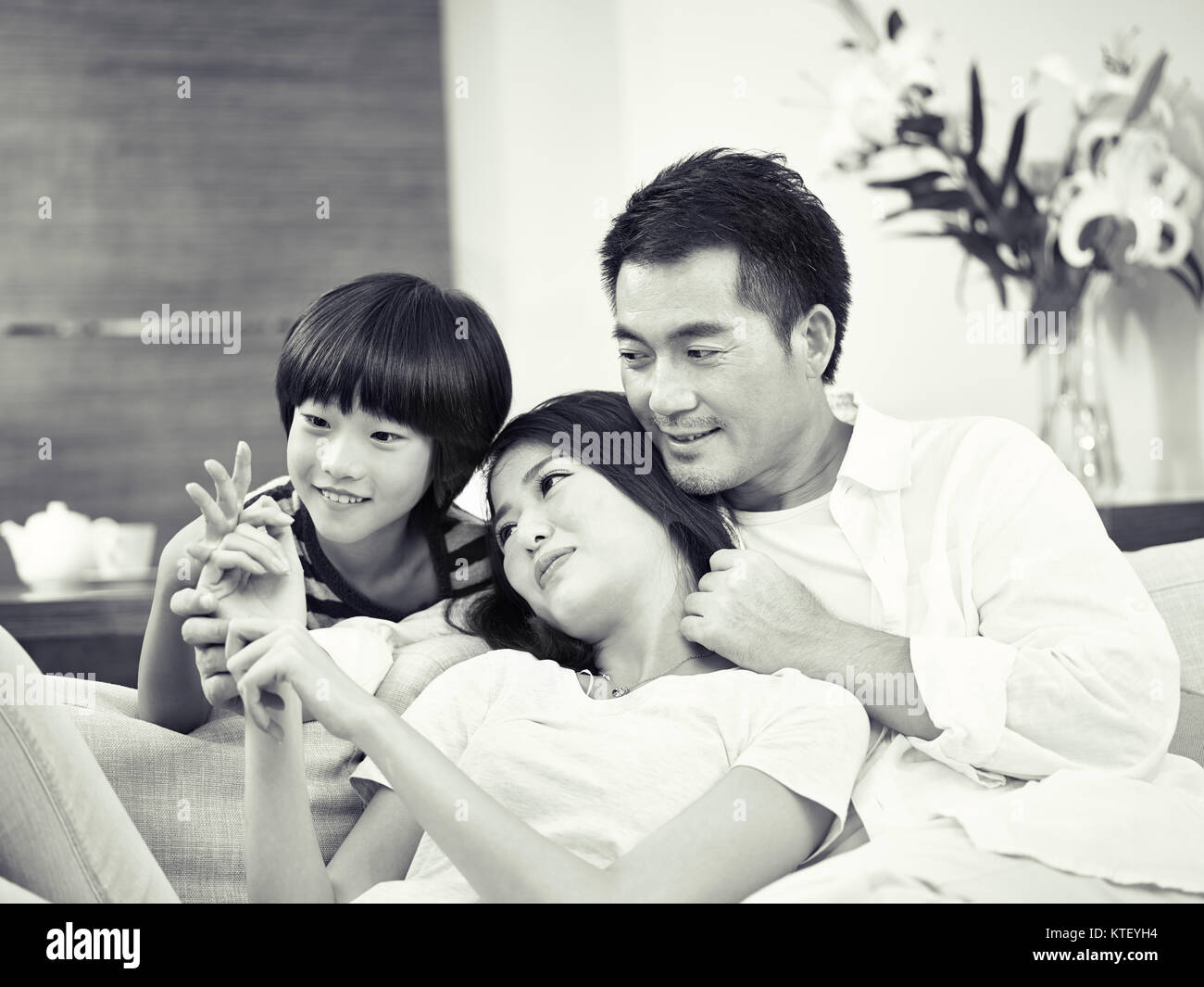 Les parents asiatiques avec un enfant bénéficiant de temps ensemble à la maison, noir et blanc Banque D'Images