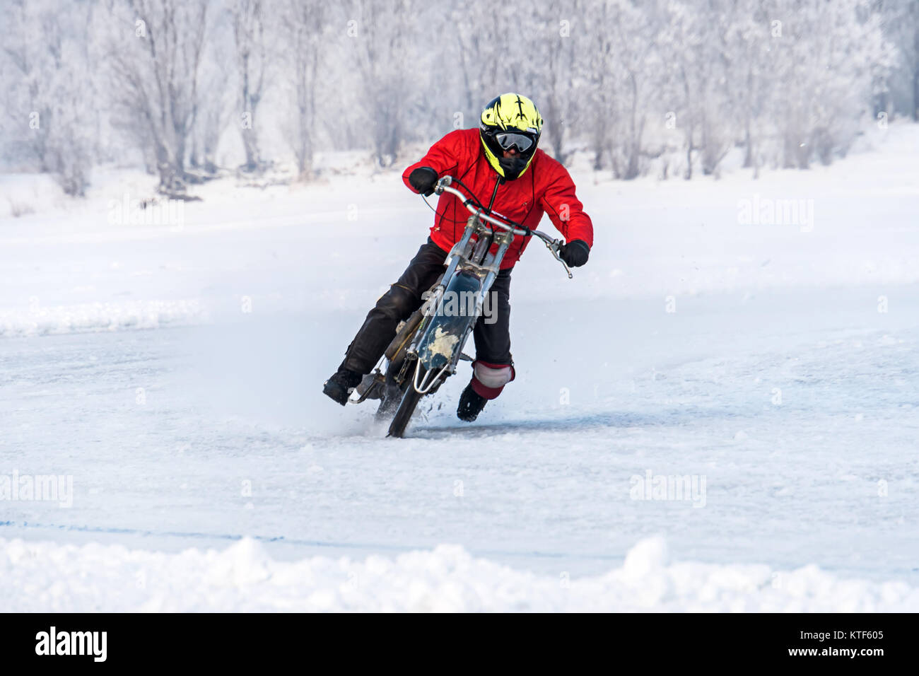 Voyages sans marque motocycliste en grande vitesse sur la glace sur un vélo d'hiver avec roues à crampons. La compétition pour le Speedway dans le danger de l'hiver. Banque D'Images