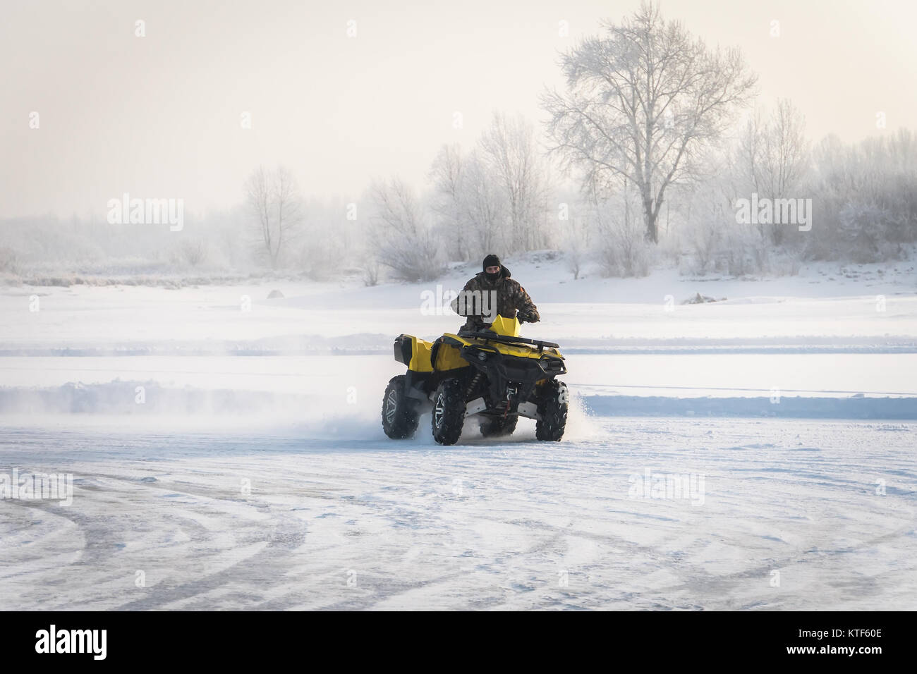 L'homme au volant d'un quad dans le champ d'hiver. extreme Moto rider en  prise sur l'ATV à l'hiver dans la neige. Le banc de neige. L'ATV a dérapé  sur le tu Photo