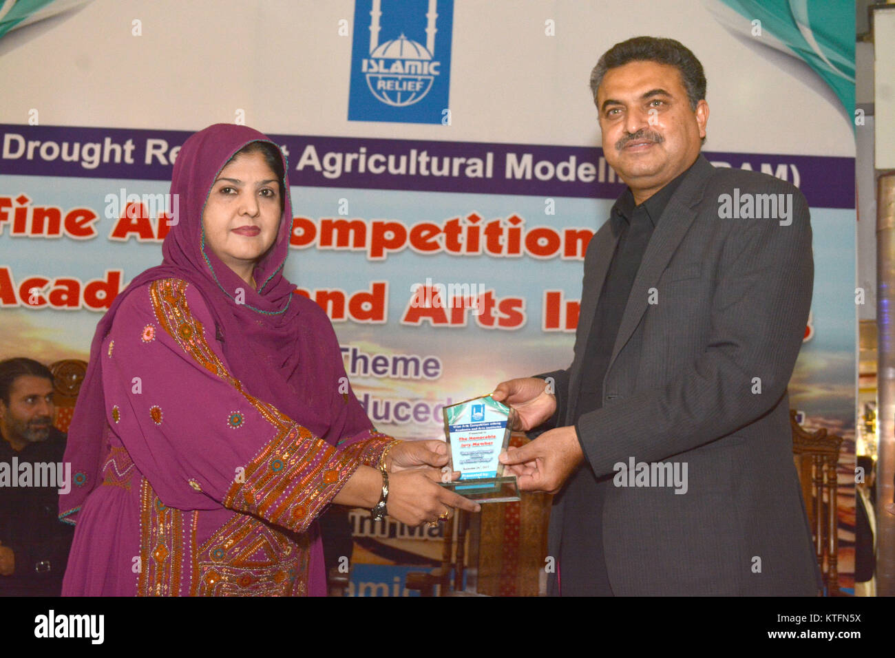 QUETTA, PAKISTAN. Déc-24 2017 : secrétaire de la Culture, du Tourisme et de l'archéologie M. Zafar Ali Buledi bouclier donnant au jury et membre de l'équipe Président SBK du département des Beaux-Arts de l'université des femmes Mme hajra Bano au cours de beaux-arts de la concurrence sur la modélisation de l'Agriculture résiliente la sécheresse au centre commercial du millénaire à Quetta au Pakistan. Organisé par le Secours Islamique Banque D'Images