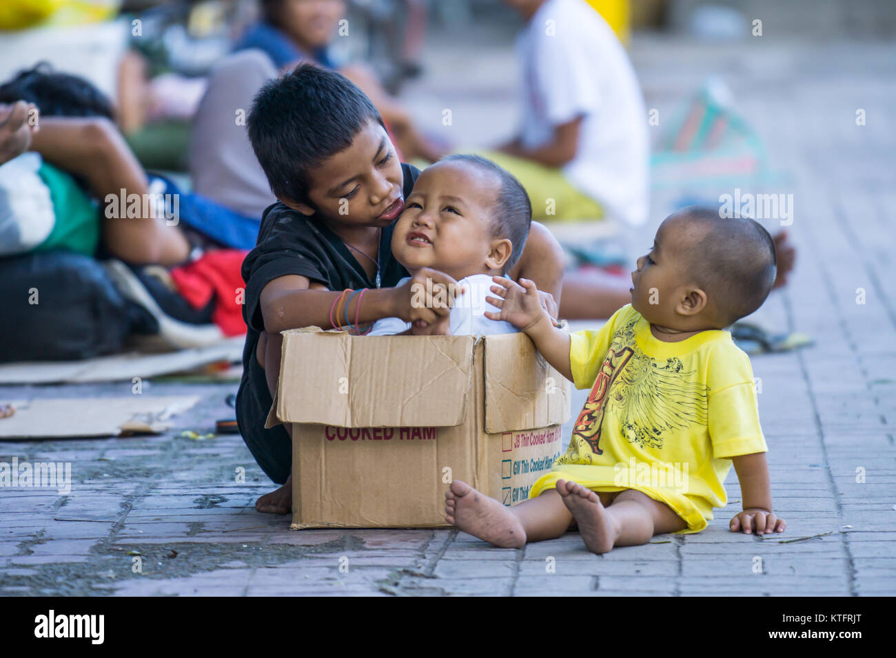 La ville de Cebu, aux Philippines. Dec 25, 2017. Les sans-abri des enfants jouant avec une boîte sur le trottoir pendant le jour de Noël 2017,matin,la ville de Cebu Philippines Crédit : gallerie2/Alamy Live News Banque D'Images