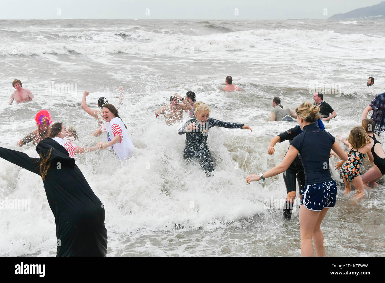 Charmouth, Dorset, UK. Le 25 décembre 2017. Des gens habillés en fancy dress costumes braver le froid le vent et la mer agitée pour le Jour de Noël nager à Charmouth plage dans le Dorset. La natation a été officiellement annulée par la RNLI fêtards mais hardy a pris à l'état de la mer est de toute façon. Crédit photo : Graham Hunt/Alamy Live News Banque D'Images