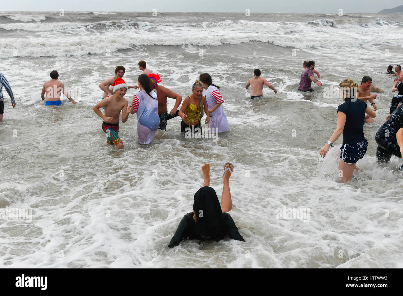 Charmouth, Dorset, UK. Le 25 décembre 2017. Des gens habillés en fancy dress costumes braver le froid le vent et la mer agitée pour le Jour de Noël nager à Charmouth plage dans le Dorset. La natation a été officiellement annulée par la RNLI fêtards mais hardy a pris à l'état de la mer est de toute façon. Crédit photo : Graham Hunt/Alamy Live News Banque D'Images