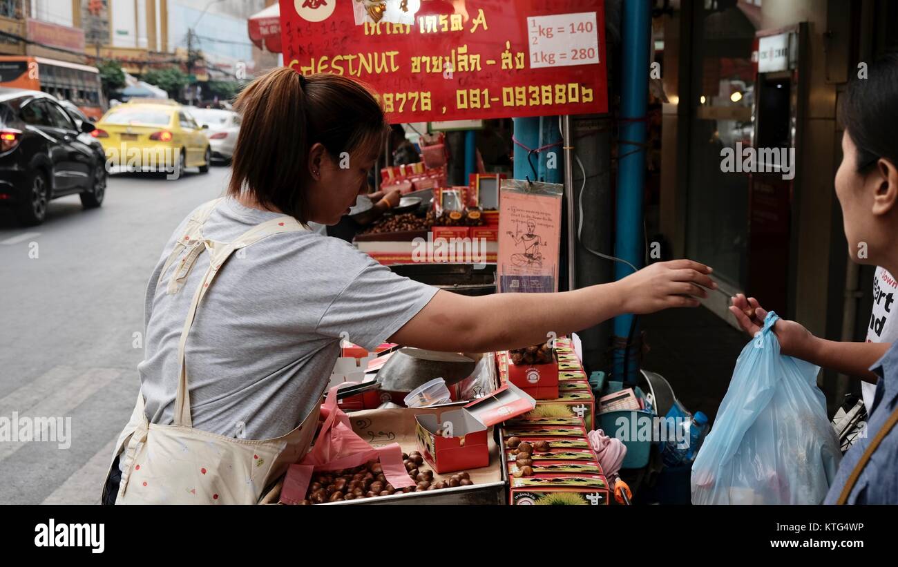 Yaowarat Road Chinatown Bangkok Thailand Street Vendor donnant le changement à un client acheteur et vendeur d'affaires Banque D'Images