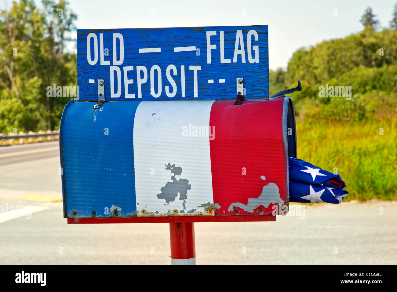 Boîte aux lettres rurales pliée contenant de l'ancien drapeau américain. Banque D'Images