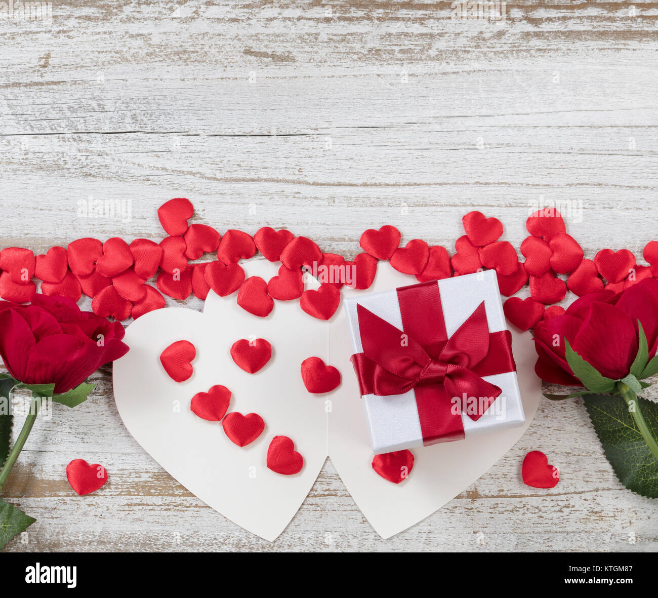 Carte de Saint-Valentin, avec boîte cadeau coeur rouge formes et roses sur blanc rustique en bois télévision vue laïcs Banque D'Images