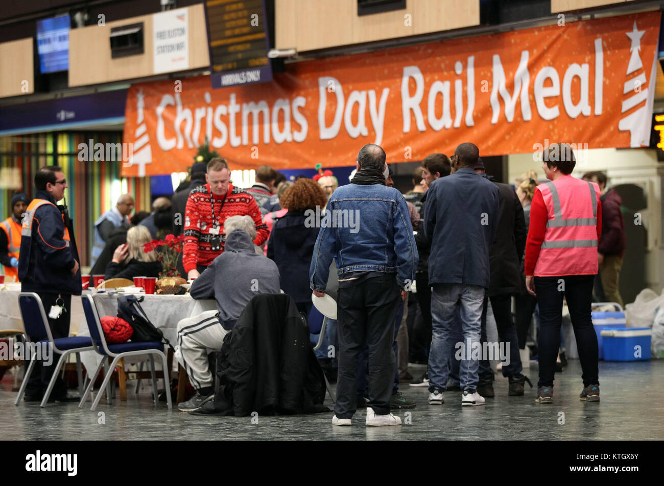 Network Rail bénévoles et ceux d'autres organismes de bienfaisance bienvenue les sans-abri dans le hall des arrivées et départs à la gare de Euston pour un repas de Noël. Banque D'Images