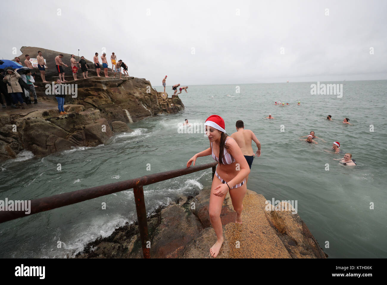Les gens brave la pluie pour prendre part à la Journée annuelle de Noël nager dans les quarante pied, Dun Laoghaire. Banque D'Images