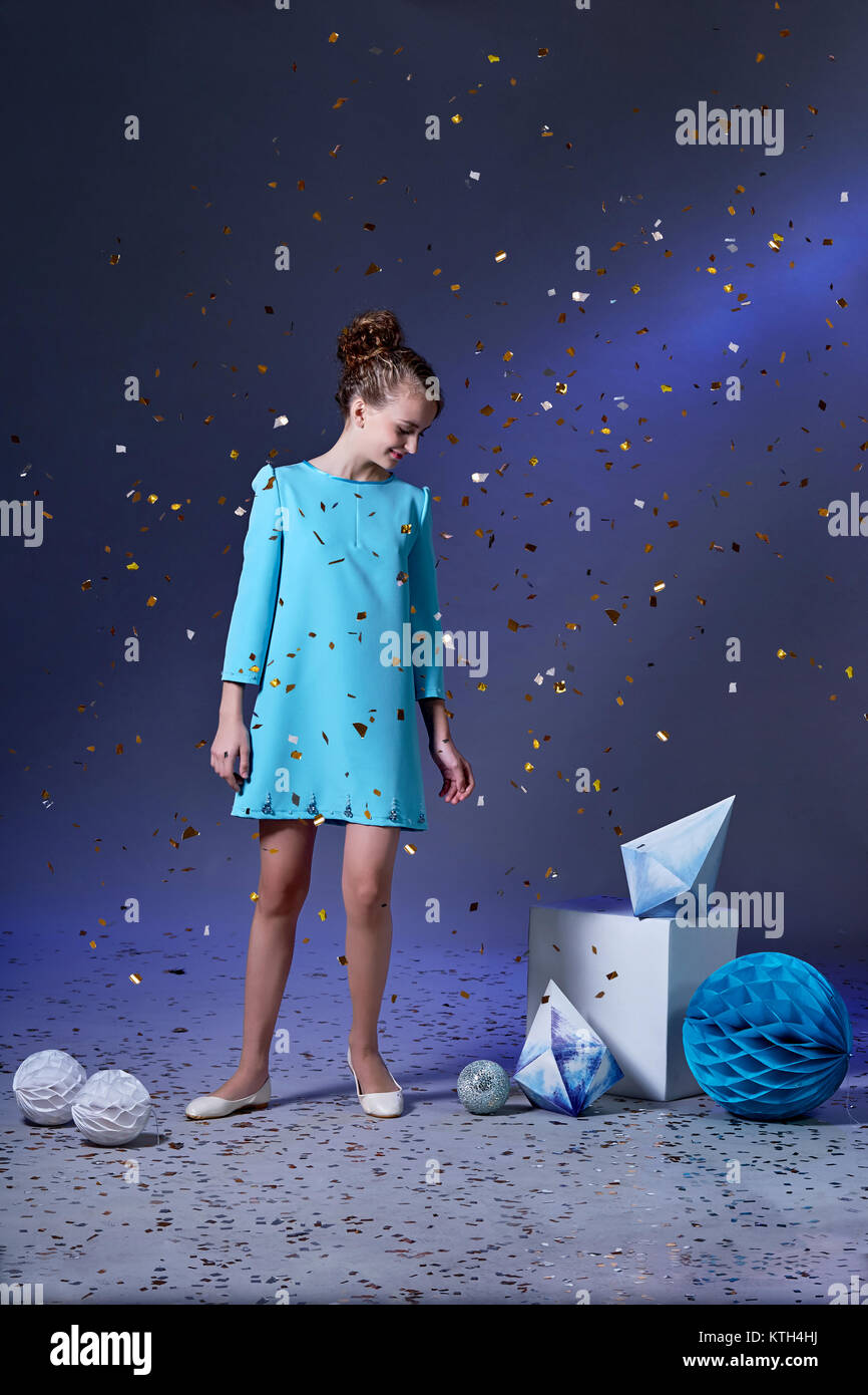 Jolie fille dans une élégante robe bleue pour les adolescentes avec un  make-up. Fête du Nouvel An.du minimalisme et de l'origami.Fashion photos de  Noël pour enfants Photo Stock - Alamy