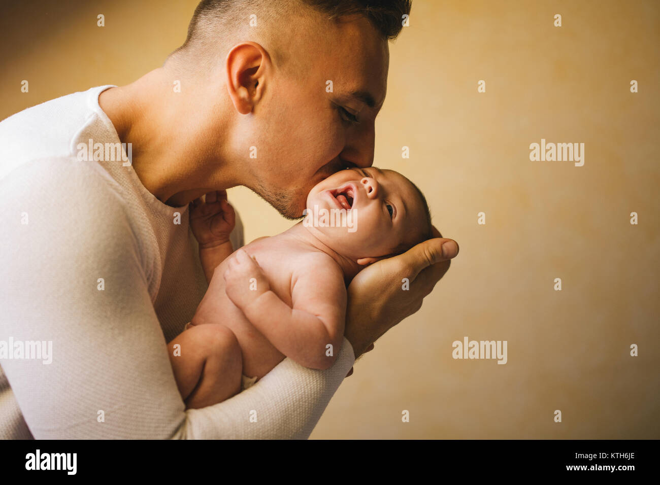 Père holding newborn baby et fenêtre près de l'embrasser Banque D'Images