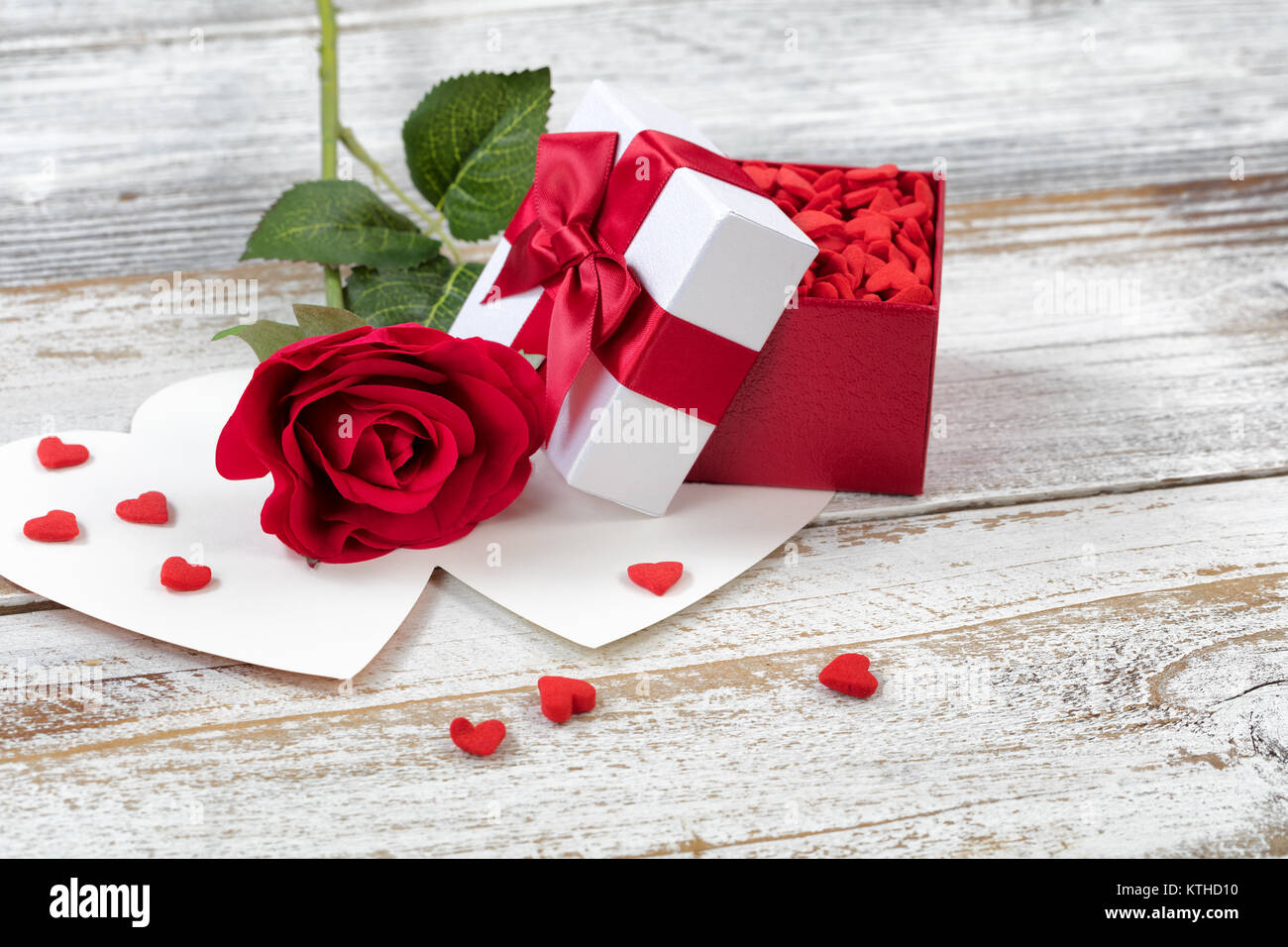 Ouvrir boîte cadeau Saint Valentin remplis de bonbons et rose rouge sur blanc rustique en bois vue en gros Banque D'Images