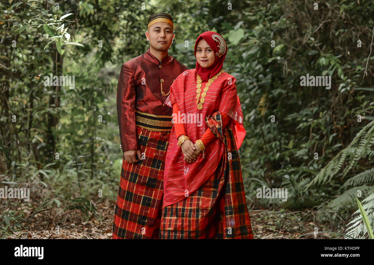 Un jeune couple pose en robe traditionnelle Bugis. Banque D'Images