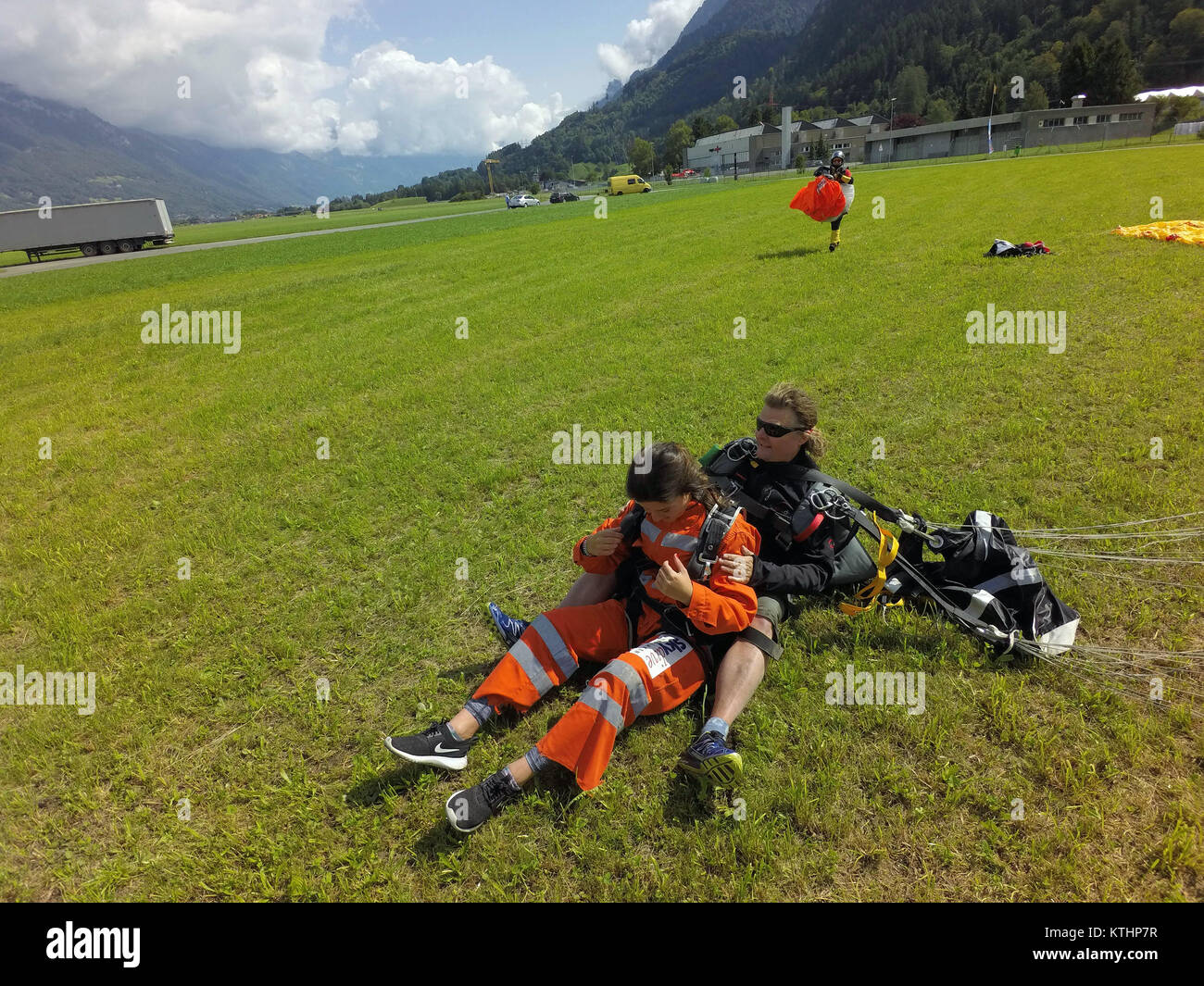 Un gros smiley est à voir sur le passager skydiving tandem après un atterrissage réussi. Elle est si heureuse qu'elle saute à nouveau immédiatement. Banque D'Images