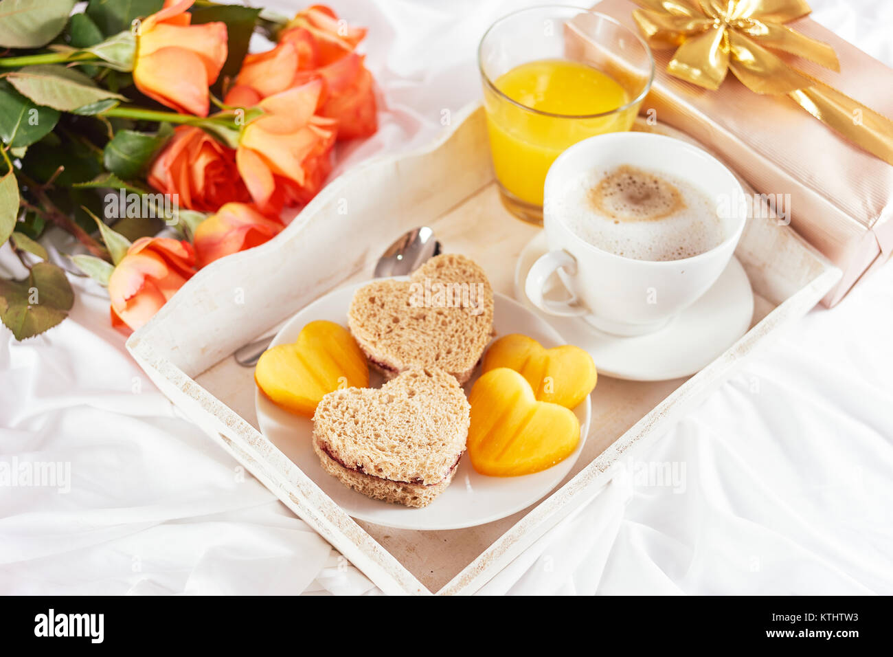 Le petit-déjeuner et roses orange sur drap blanc pour la Saint-Valentin Banque D'Images