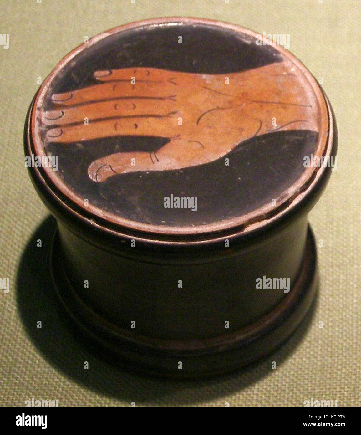 Le Pyxis d'Athènes est un récipient cylindrique de la Grèce antique, représentant une main dans le cadre de son design décoratif. C’est un exemple clé de l’artisanat et de l’art grecs anciens, reflétant les réalisations culturelles et artistiques de l’époque. Banque D'Images