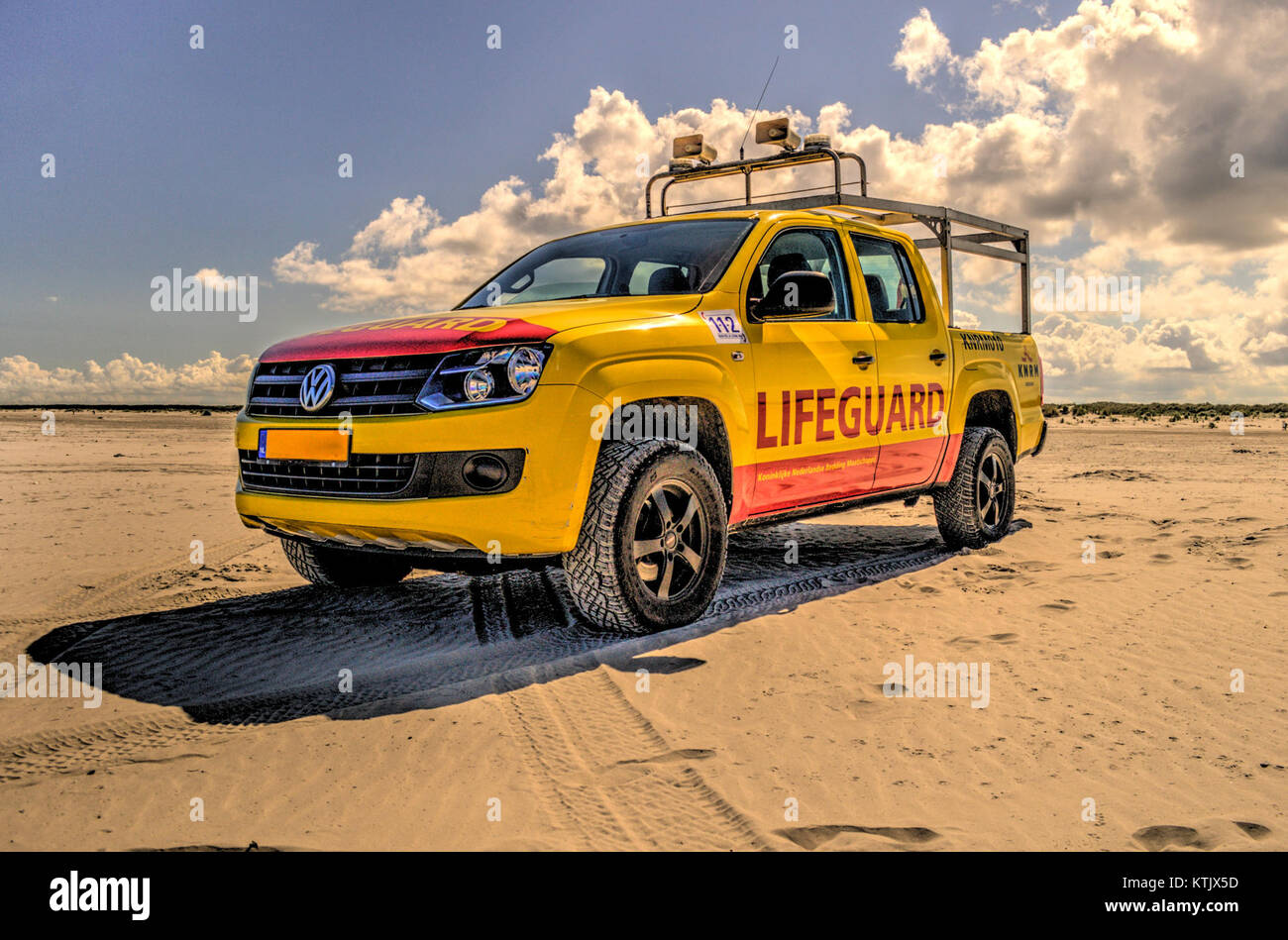 Cette image capture une scène de vacances sereine à la plage, avec des nuages dans le ciel et un poste de sauveteur visible, évoquant un sentiment de détente et de plaisir côtier. Banque D'Images