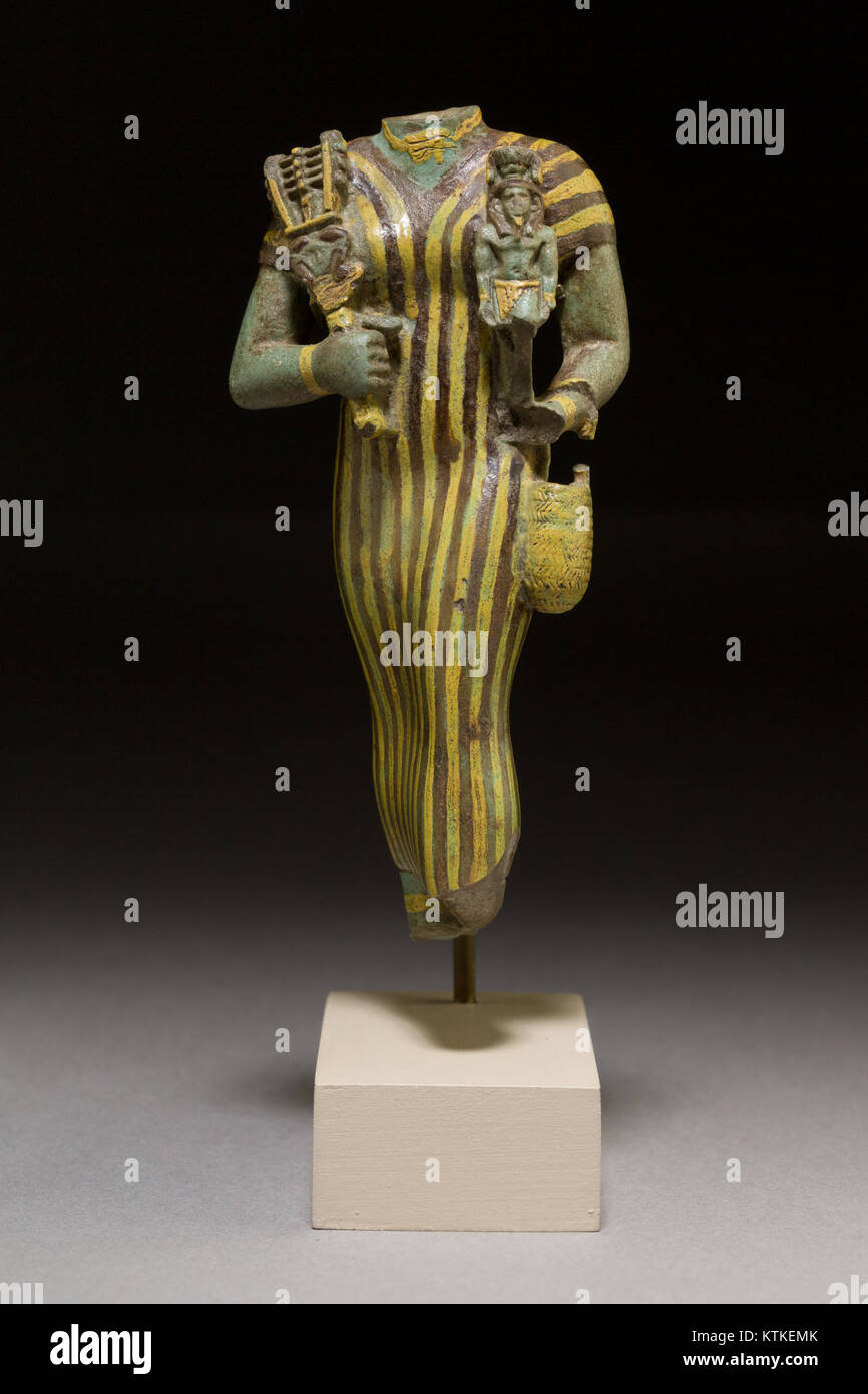 Cet artefact égyptien présente une représentation de la déesse Bastet avec une figure de Néfertum, un sistrum (instrument de musique) et un panier. Il représente le symbolisme religieux et culturel égyptien antique, avec des références aux dieux et aux rituels. Banque D'Images