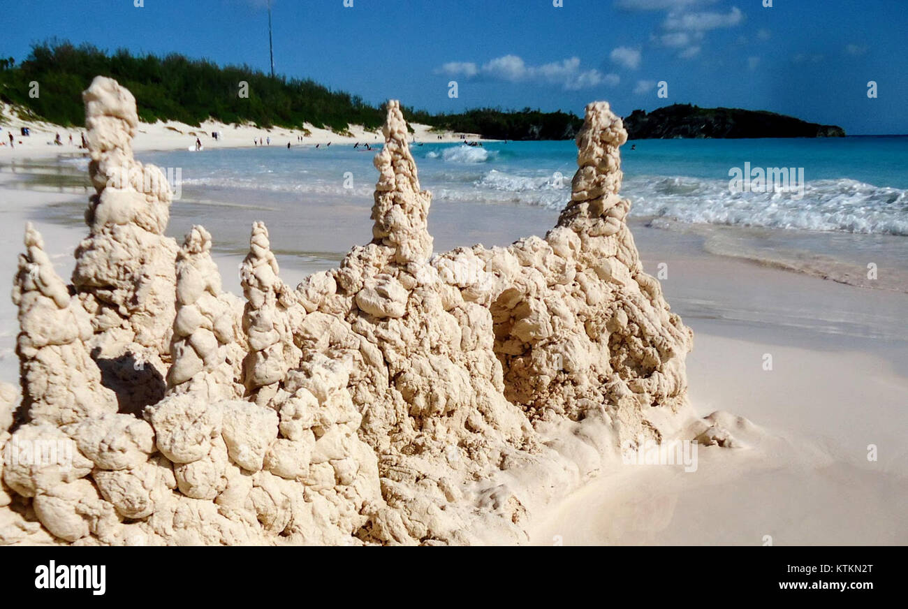 Une photographie d'un château de sable à Horseshoe Bay Beach aux Bermudes, capturant la formation de sable unique avec des flèches océaniques et des nuages en arrière-plan. Banque D'Images
