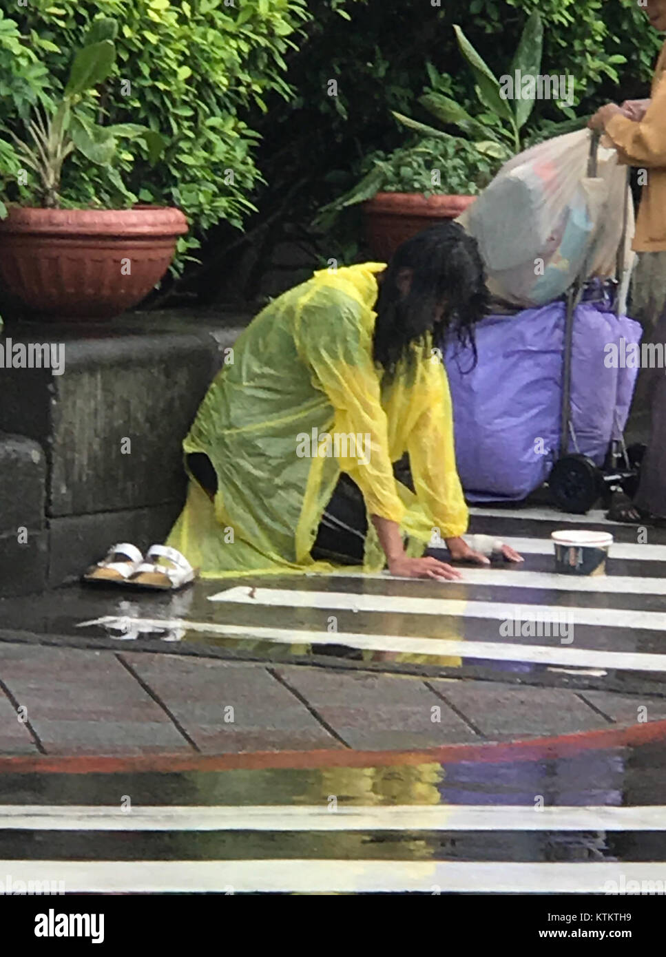Un mendiant portant des vêtements de pluie est vu à l'entrée du site ouest de l'hôpital NTU, illustrant l'intersection de la pauvreté et des espaces publics. La scène capture un moment de vulnérabilité dans la vie urbaine, mettant en évidence les défis sociaux et la disparité entre les situations individuelles dans les milieux métropolitains. Banque D'Images Un mendiant portant des vêtements de pluie est vu à l'entrée du site ouest de l'hôpital NTU, illustrant l'intersection de la pauvreté et des espaces publics. La scène capture un moment de vulnérabilité dans la vie urbaine, mettant en évidence les défis sociaux et la disparité entre les situations individuelles dans les milieux métropolitains. Banque D'Images