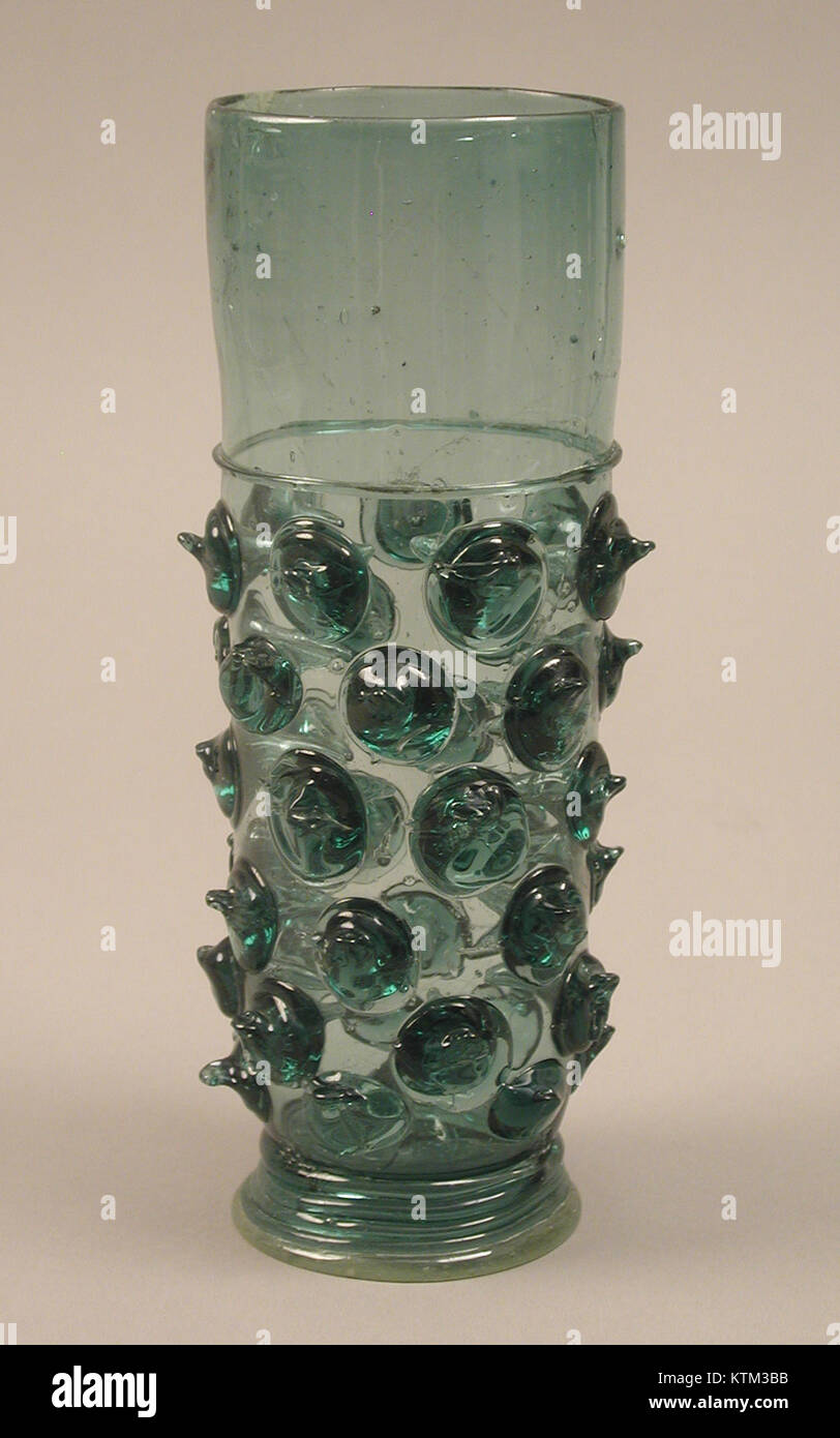Photographie d'un bécher en verre allemand du XVIe siècle de la collection du Metropolitan Museum of Art (numéro d'entrée MET sf27 185 203S1). Mesurant environ 8,6 pouces de haut, le bécher présente des décorations complexes en émail représentant un colporteur volé par des singes, illustrant une légende populaire sur la folie de l'homme. Banque D'Images