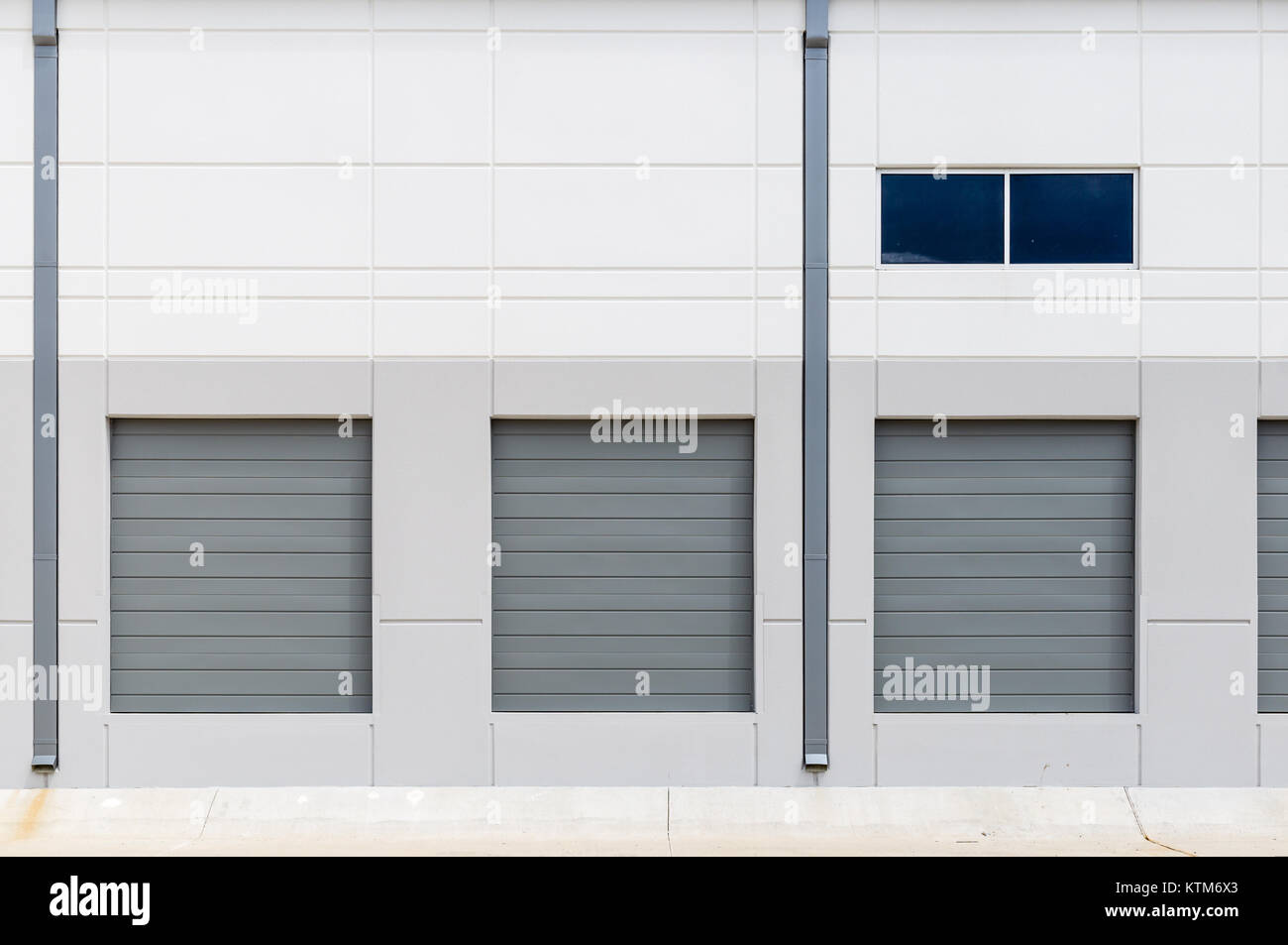 Nouvelle construction de quais de chargement de l'entrepôt de murs blanc portes coulissantes en métal gris Banque D'Images