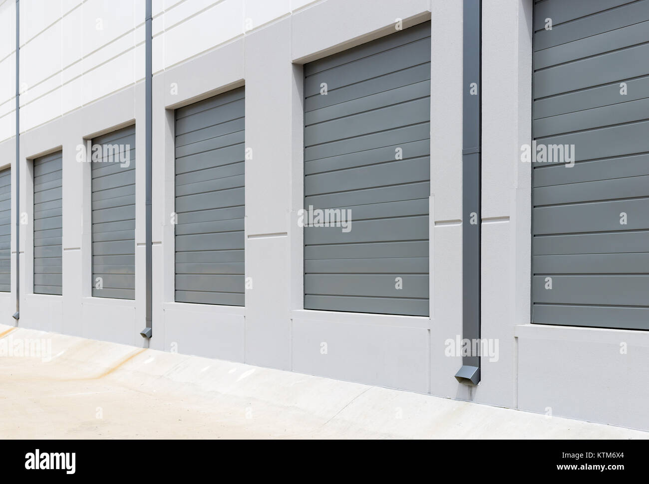 Nouvelle construction de quais de chargement de l'entrepôt de murs blanc portes coulissantes en métal gris Banque D'Images